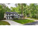 Expansive front yard with mature trees and lush greenery complementing the charming two-story home and long driveway at 3270 Brookview Dr, Marietta, GA 30068