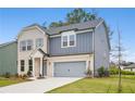Two-story home with brick and siding, showcases a well-manicured lawn and attached garage at 5383 Heron Bay Blvd, Locust Grove, GA 30248