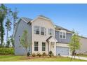 View of a two-story home with light brick, gray siding, and a well-kept lawn and landscape at 5383 Heron Bay Blvd, Locust Grove, GA 30248