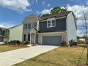Charming two-story home with a combination brick and siding exterior, attached garage, and long driveway at 5383 Heron Bay Blvd, Locust Grove, GA 30248