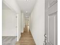 Inviting hallway featuring light wood floors and neutral walls that lead to other rooms at 5383 Heron Bay Blvd, Locust Grove, GA 30248
