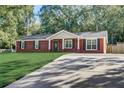 Beautiful single-story brick home with a spacious driveway and well-maintained lawn at 715 Cowan Rd, Covington, GA 30016