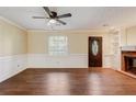 Bright living room with hardwood floors, neutral paint, ceiling fan, and cozy fireplace at 715 Cowan Rd, Covington, GA 30016