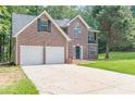 Two-story brick home featuring an attached two-car garage, dark shutters, and a lush green lawn at 99 Ashtonbrook Dr, Mcdonough, GA 30252