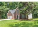 Traditional brick house featuring a green lawn and mature trees in a peaceful setting at 99 Ashtonbrook Dr, Mcdonough, GA 30252