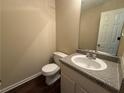 Powder room featuring granite countertop vanity and white toilet at 99 Ashtonbrook Dr, Mcdonough, GA 30252