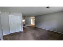 Spacious living room with plush carpeting and a neutral color palette, open to dining area and kitchen at 5266 Long Green Ln, Stone Mountain, GA 30088