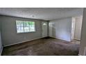 Inviting living room with soft carpeting, a large window providing natural light, and neutral wall paint at 5266 Long Green Ln, Stone Mountain, GA 30088