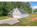 A view of the exterior of the home with its well-kept lawn and two-car garage at 104 Federal Path, Temple, GA 30179