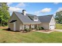 Exterior view of home showcasing the roofline, manicured lawn and covered front porch at 104 Federal Path, Temple, GA 30179
