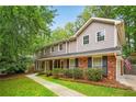 Beautiful two-story home featuring a brick facade, gray siding, and well-maintained landscaping at 3932 Granger Dr, Brookhaven, GA 30341