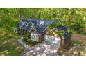 Aerial view of brick home with well-maintained yard, long driveway and mature trees in the background at 4703 Waverly Walk, Douglasville, GA 30135