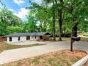 Exterior shot of a one story home featuring a long driveway, front lawn, and inviting covered porch area at 5840 Crabapple Sw Dr, Mableton, GA 30126