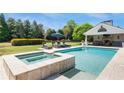 Backyard with a refreshing pool, a tanning deck with lounge chairs, and outdoor fireplace at 210 Tifton Ln, Roswell, GA 30075
