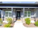 Inviting front porch with stone pillars and stylish black door and fixtures at 2710 Sandy Irwin Sw Ct, Marietta, GA 30064