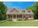 Inviting home with stone accents, a covered porch, and meticulously maintained landscaping at 313 Red Fox Dr, Canton, GA 30114