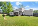 Spacious backyard featuring a covered patio, lush green lawn, and wood fencing for privacy at 660 Cranberry Ct, Roswell, GA 30076