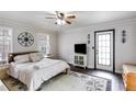Spacious main bedroom with neutral paint, hardwood floors, crown molding, ceiling fan, and private door to outside at 115 N Loblolly Xing, Temple, GA 30179