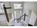 View of the home's entryway from the staircase landing with elegant chandelier at 4199 Wyndham Park Way, Buford, GA 30519