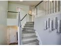 Elegant staircase featuring gray wood steps and white and gray railings at 4199 Wyndham Park Way, Buford, GA 30519