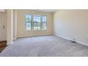 Bright living room features plush carpeting, neutral walls, and an abundance of natural light at 23 Dynasty Dr, Fairburn, GA 30213