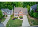 An aerial view of a brick front house with a well-kept lawn in a suburban neighborhood at 1099 Mount Water Ln, Lawrenceville, GA 30043