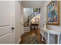 Elegant foyer with hardwood floors, staircase, baby grand piano, and sophisticated decor at 235 Cornerstone Dr, Woodstock, GA 30188