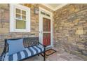 Cozy front porch with stone facade, a comfortable bench, and a welcoming entrance at 235 Cornerstone Dr, Woodstock, GA 30188