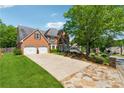 Charming two-story brick home featuring a two-car garage and a stone driveway border at 579 Delphinium Nw Blvd, Acworth, GA 30102