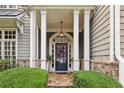 Elegant home exterior showcasing a covered front entrance with stone accents and manicured landscaping at 1153 Brookhaven Commons Ne Dr, Brookhaven, GA 30319