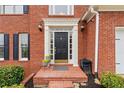 Elegant brick entryway with a black front door and decorative columns at 1988 Claiborne Ct, Marietta, GA 30062