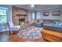 Cozy living room featuring a brick fireplace, hardwood floors, and comfortable seating area at 4579 Amberly S Ct, Atlanta, GA 30360