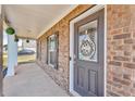 Inviting front door with decorative wreath and a covered porch with brick pillars at 206 Prescott St, Locust Grove, GA 30248