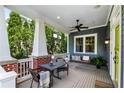 Relaxing front porch with a ceiling fan, porch swing, table and chairs, and charming details at 132 Olympic Pl, Decatur, GA 30030