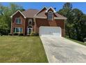 Traditional brick home with a well-maintained lawn and an attached two-car garage at 2246 Carrington Dr, Ellenwood, GA 30294