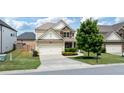 Two-story home with manicured lawn and front-facing two-car garage at 3625 New River Ct, Cumming, GA 30040