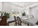 Elegant dining room with dark hardwood floors, wainscoting, table, and a modern chandelier at 5749 Creek Indian Dr, Sugar Hill, GA 30518