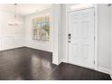 Bright entryway with dark wood floors, white wainscoting, and a view to a dining area at 5749 Creek Indian Dr, Sugar Hill, GA 30518