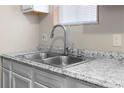 Close-up of the kitchen sink with modern faucet, granite countertop, and window view at 60 Highland Dr, Stockbridge, GA 30281
