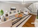 Bright, staged living room featuring hardwood floors, staircase, and abundant natural light at 6980 Roswell Rd # J6, Atlanta, GA 30328