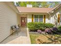 Inviting front porch with decorative bench and a well-manicured garden landscape at 6095 Wayfarer Dr, Villa Rica, GA 30180