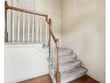 Carpeted staircase featuring white spindles and a wooden banister leading to the upper level at 44 Saint Claire Ne Ln, Atlanta, GA 30324