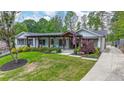 Charming home showcasing covered porch with wood columns, lush lawn, and landscaped yard at 2668 Galahad Ne Dr, Atlanta, GA 30345