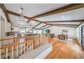 Open-concept living area with hardwood floors, exposed beams, designer lighting, and kitchen views at 2668 Galahad Ne Dr, Atlanta, GA 30345