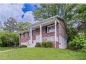Two-story brick home boasts a covered front porch and well-maintained landscaping at 5340 The Savoy St, Atlanta, GA 30349