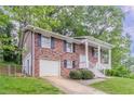 Two-story brick home with white trim, covered front porch, and attached garage at 5340 The Savoy St, Atlanta, GA 30349
