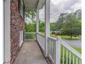 View of a covered front porch of a brick home with white railings and columns at 5340 The Savoy St, Atlanta, GA 30349