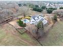An aerial view that highlights the property with its pool, paddock, outbuildings, and sprawling lawn at 401 Nichols Dr, Suwanee, GA 30024