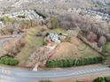 Expansive aerial view showcasing the home's setting on a large lot, complete with horse paddock, mature trees, and lush surroundings at 401 Nichols Dr, Suwanee, GA 30024