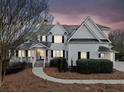 Charming front exterior showcases a two-story home with manicured landscaping, stone accents, and a covered front porch at 401 Nichols Dr, Suwanee, GA 30024